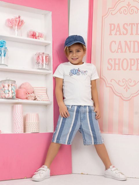 A boy leaning against a pink candy-shoppe wall