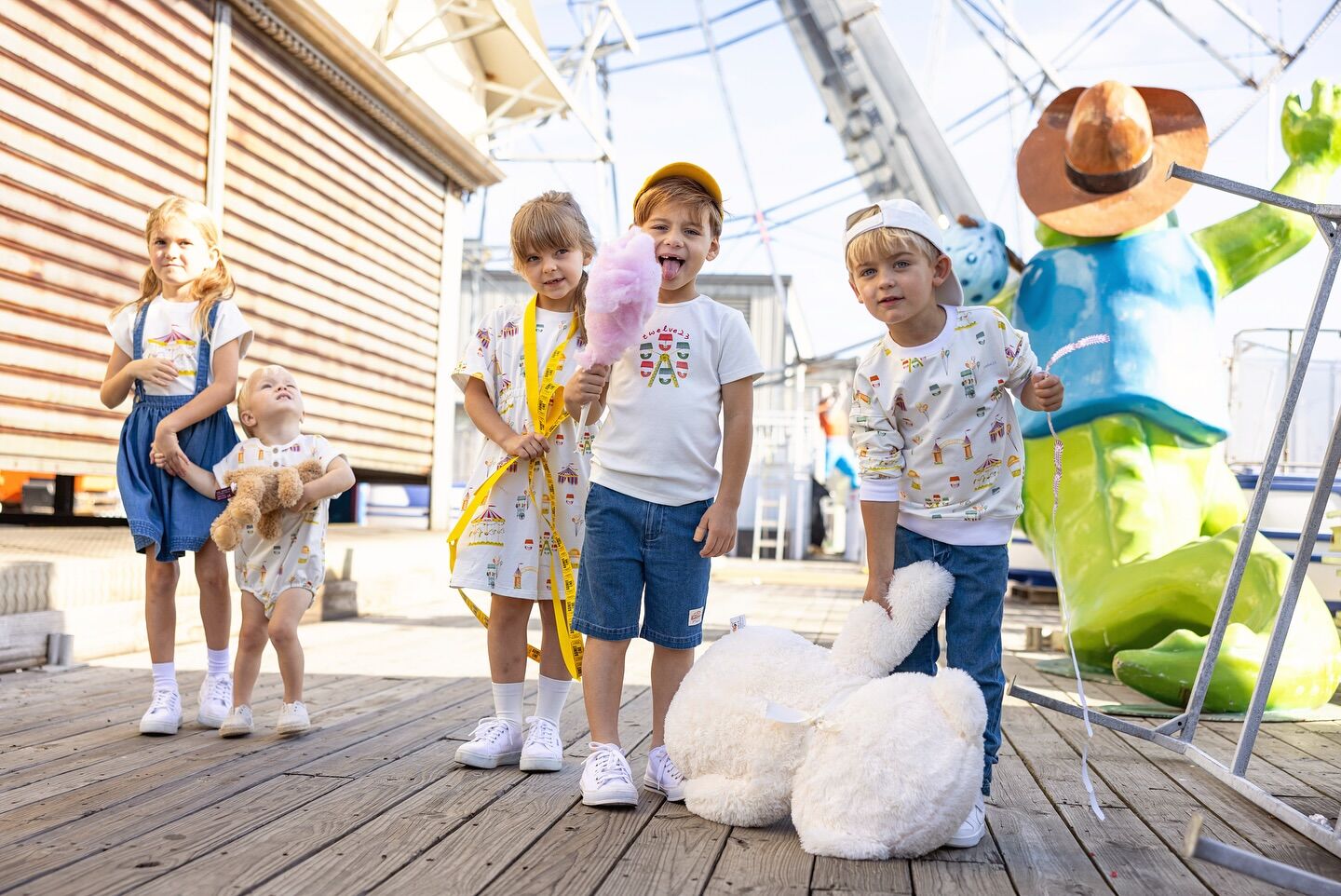 A group of children on a wooden pier with a plush bunny